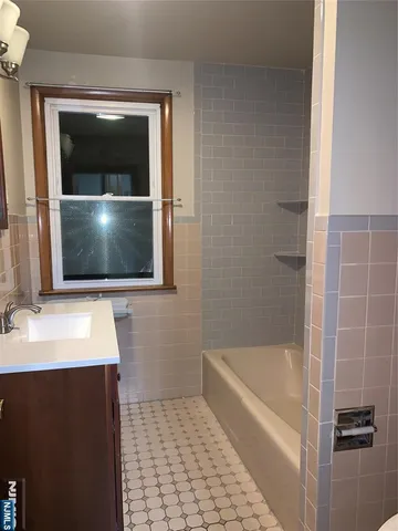 a bathroom with a sink a mirror and bathtub