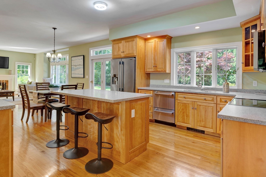 5 Chapel Hill Road Beverly, MA 01915 - Photo 14 of 41 a kitchen with stainless steel appliances granite countertop a stove a sink a dining table and chairs with wooden floor