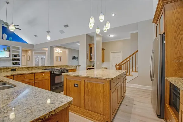 a kitchen with stainless steel appliances granite countertop a sink a stove top oven a counter space and cabinets