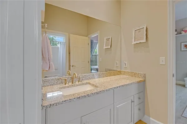 a bathroom with a granite countertop sink and a mirror