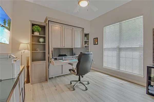 a view of a workspace with furniture and a window