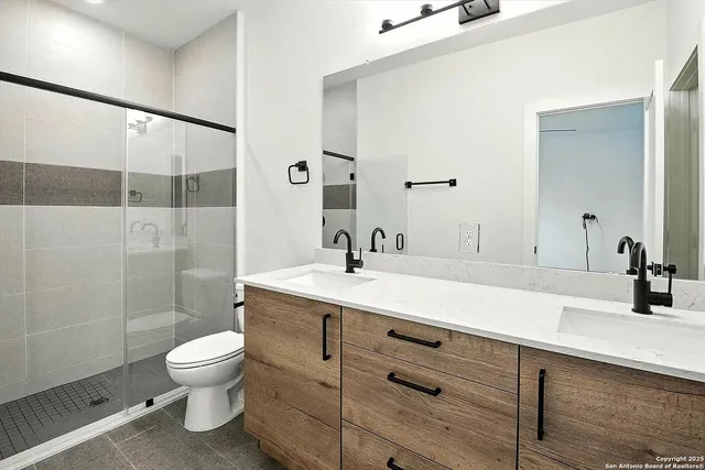 a bathroom with a sink a toilet and shower