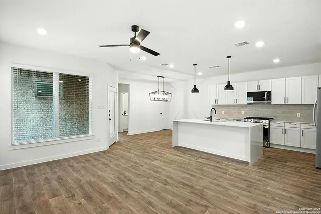 a view of kitchen with granite countertop cabinets microwave and stove