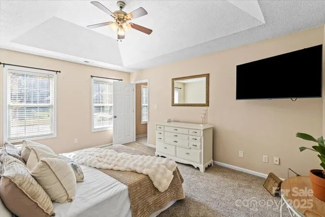 a bedroom with a bed a window and a flat screen television