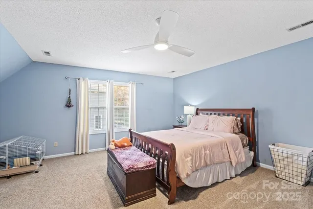 a bedroom with a bed a chandelier and a window