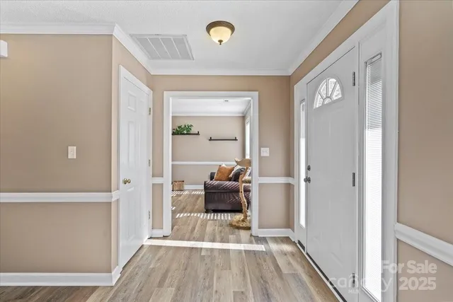 a view of a hallway with wooden floor and furniture