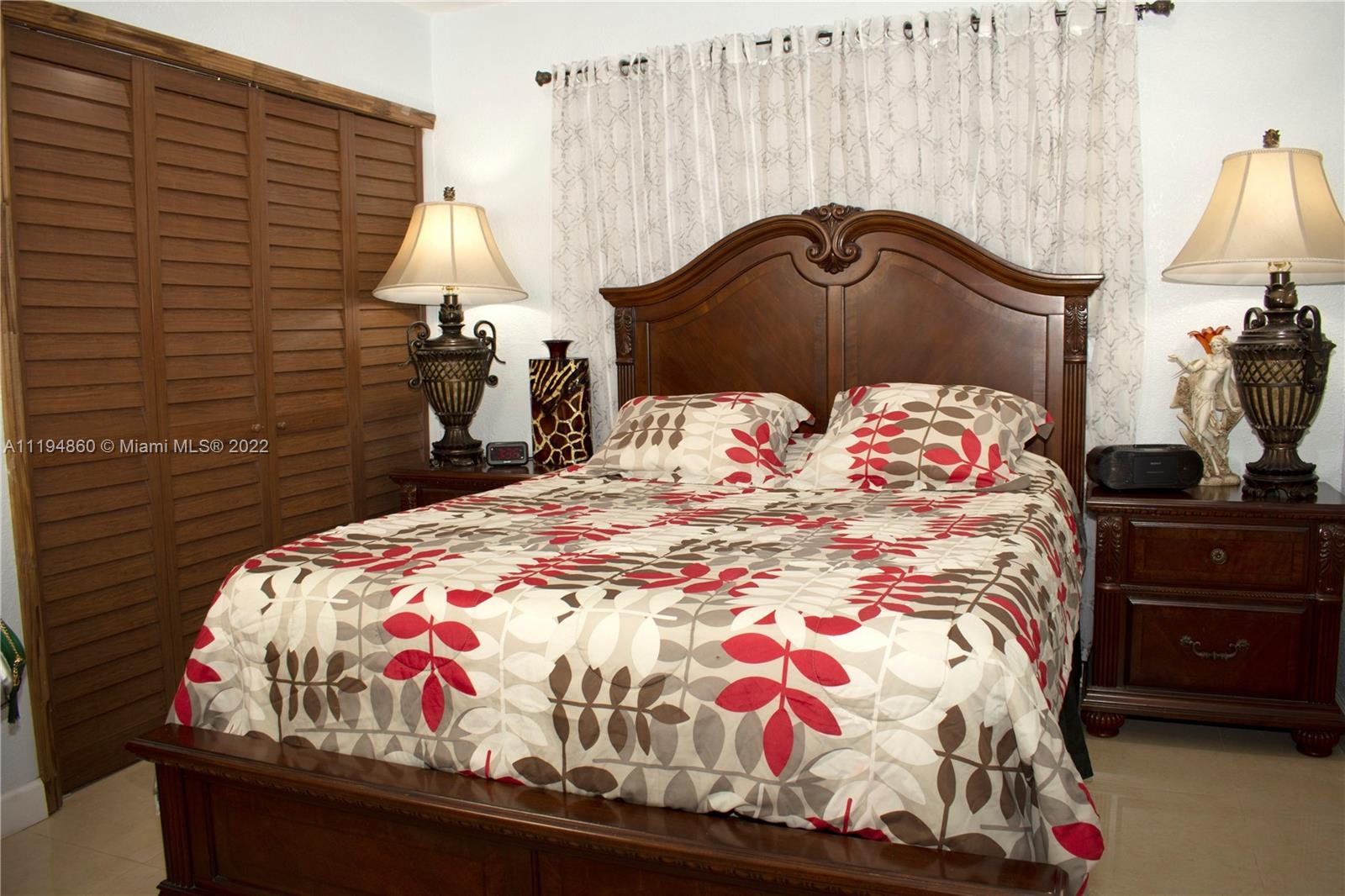 398 East 56th Street Hialeah, FL 33013 - Photo 12 of 30 a bedroom with a bed and a chandelier