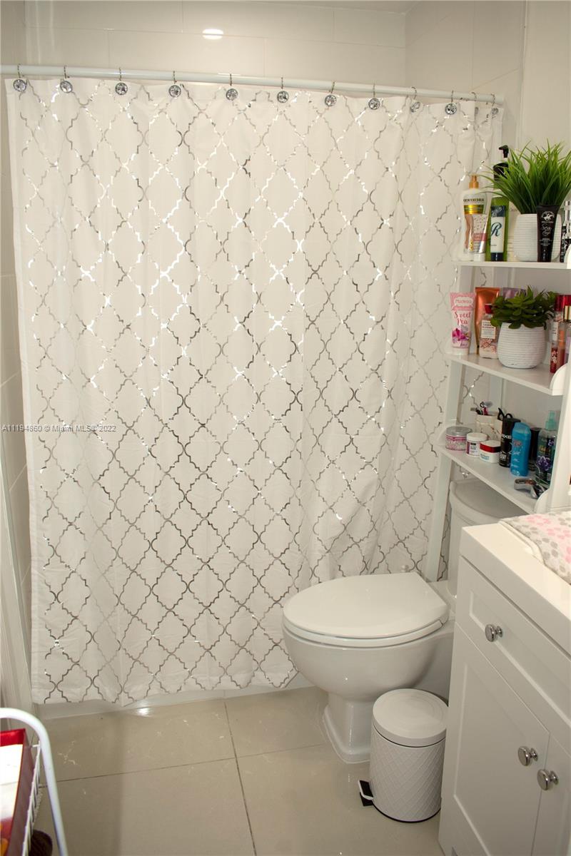 398 East 56th Street Hialeah, FL 33013 - Photo 17 of 30 a white toilet sitting next to a white curtain and a sink