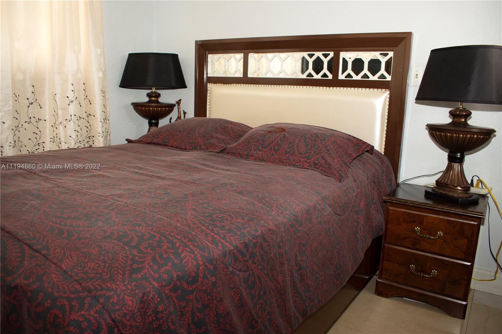 398 East 56th Street Hialeah, FL 33013 - Photo 20 of 30 a bedroom with a bed and a flat tv screen on wall