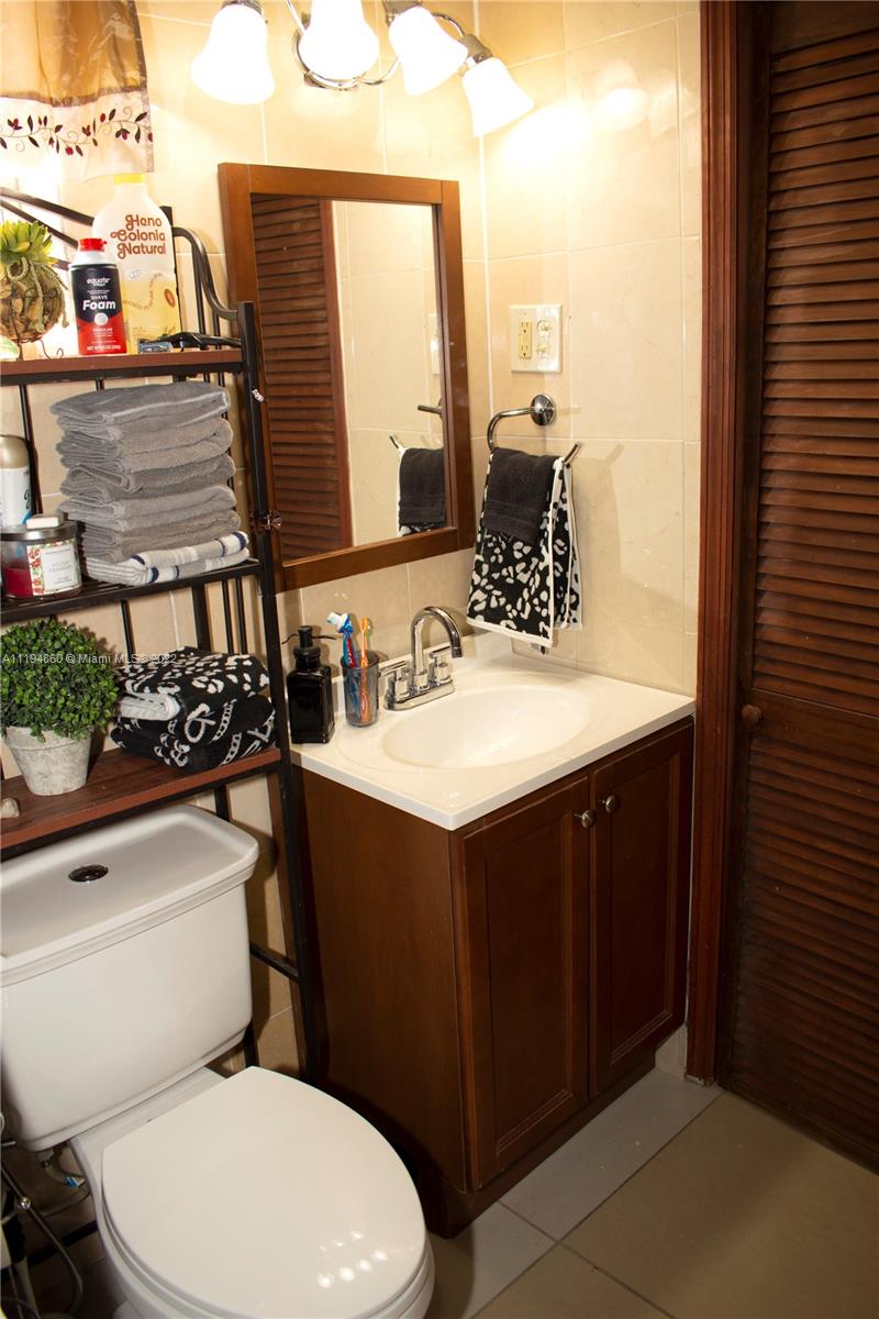 398 East 56th Street Hialeah, FL 33013 - Photo 27 of 30 a bathroom with a sink vanity mirror and toilet