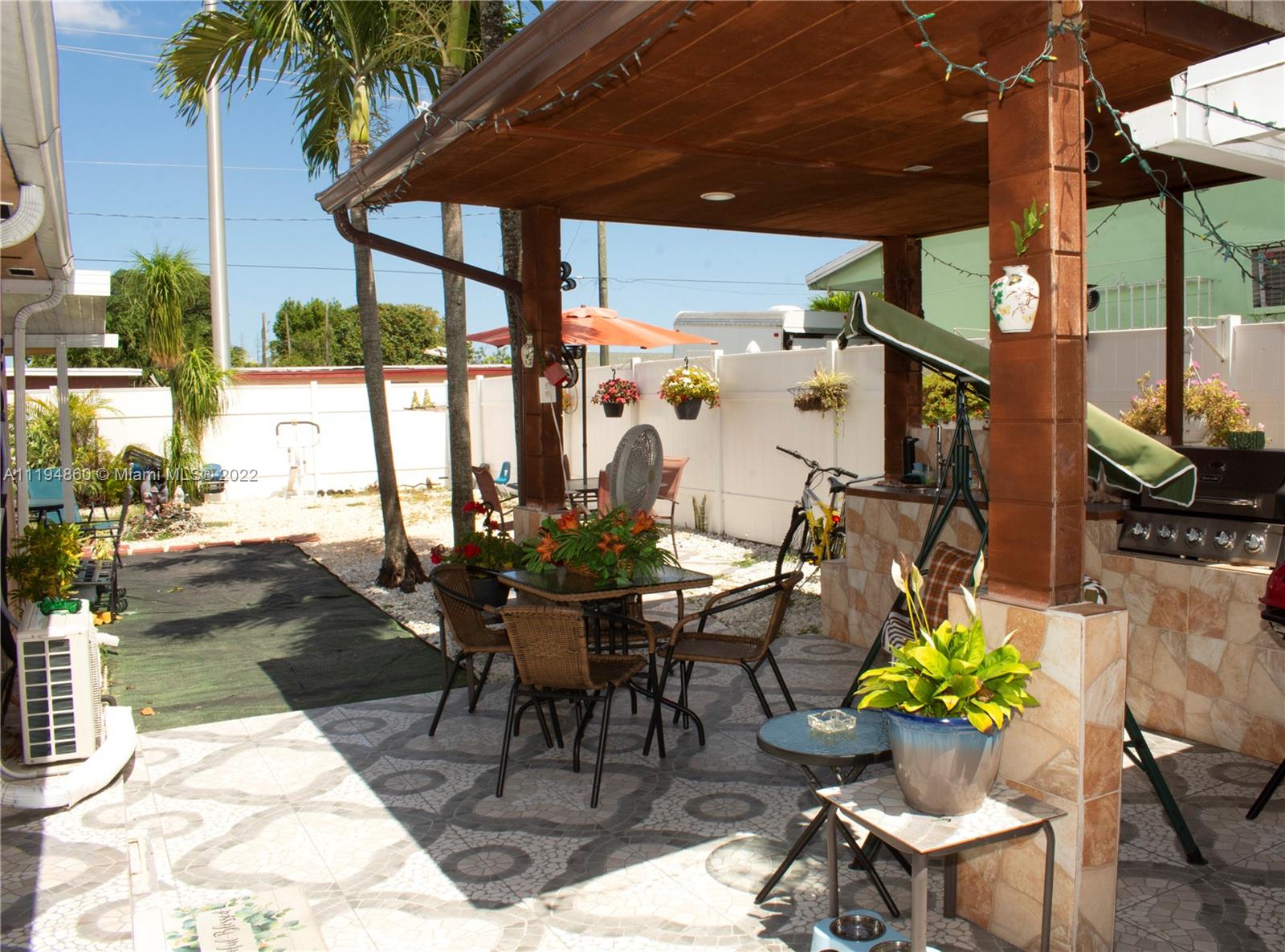 398 East 56th Street Hialeah, FL 33013 - Photo 9 of 30 a view of a patio with a dining table and chairs potted plants