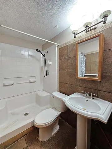 a bathroom with a sink a toilet and shower