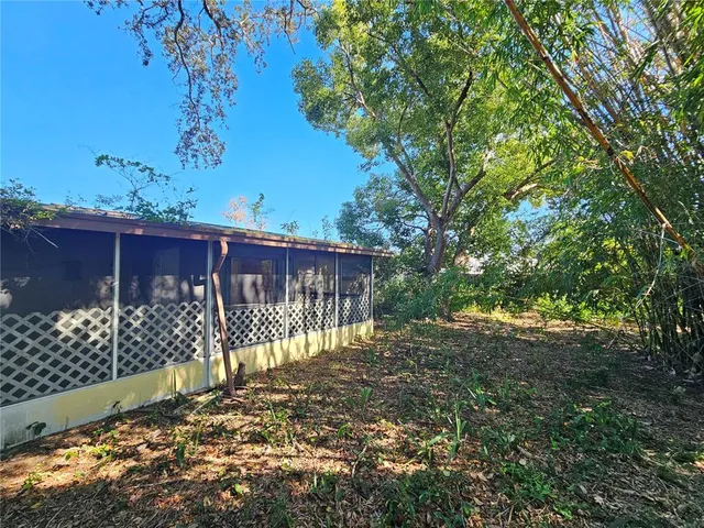 a view of backyard with wooden fence and trees