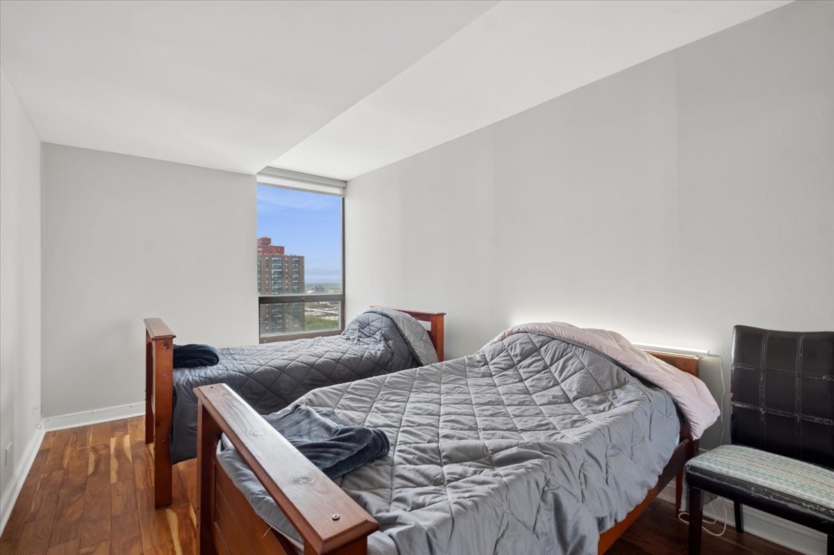 5320 North Sheridan Road, Unit 2403 Chicago, IL 60640 - Photo 11 of 18 a bedroom with a bed and wooden floor