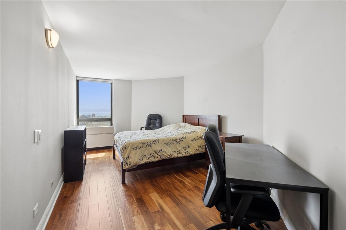 5320 North Sheridan Road, Unit 2403 Chicago, IL 60640 - Photo 8 of 18 a bedroom with a bed and wooden floor