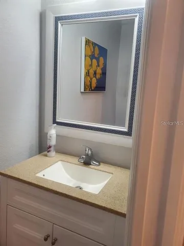 a bathroom with a granite countertop sink and a mirror