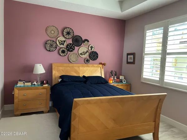 a bed sitting in a bedroom next to a window