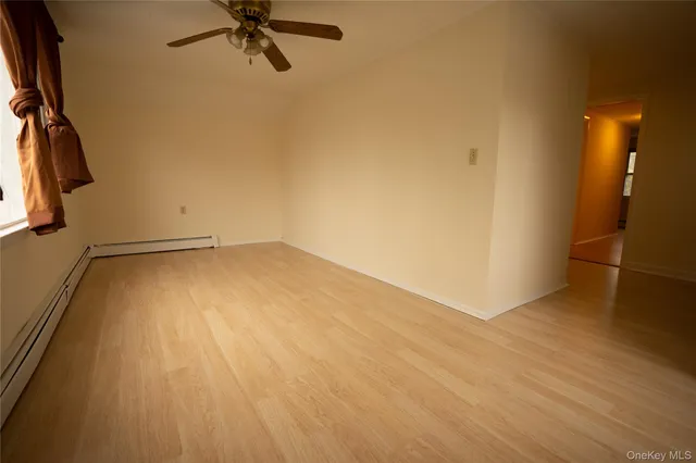 a view of a room with wooden floor and a ceiling fan