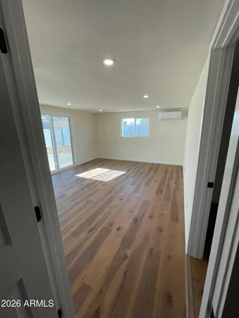 a view of empty room with wooden floor
