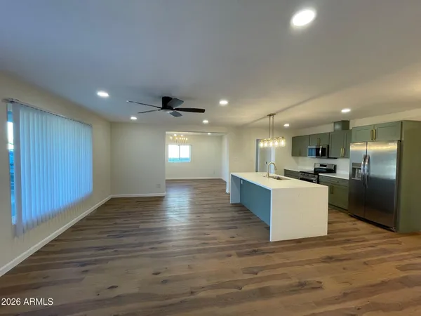 a view of kitchen with kitchen island sink refrigerator and window