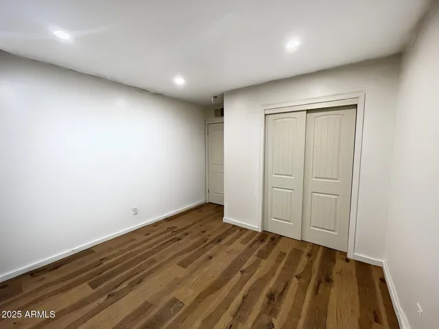 an empty room with wooden floor and closet