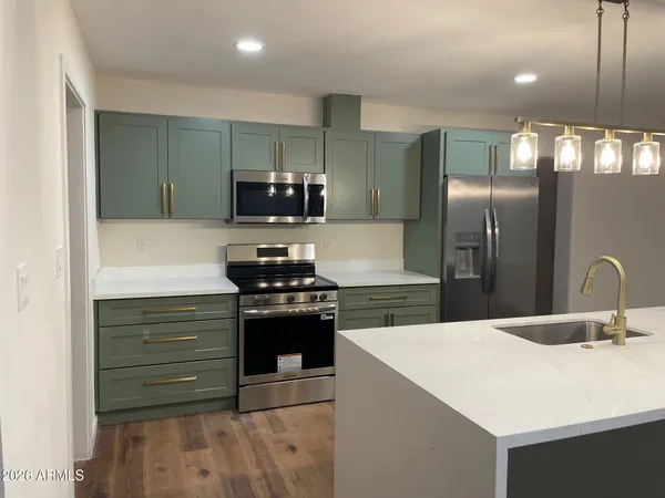 a kitchen with stainless steel appliances kitchen island a sink stove and refrigerator