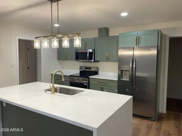 a kitchen with stainless steel appliances a sink and refrigerator