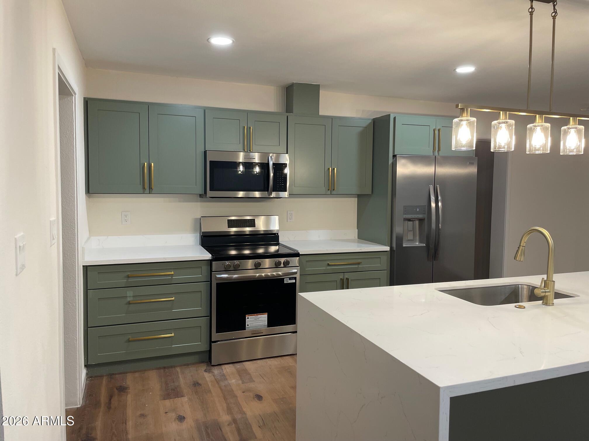 1819 West Morten Avenue Phoenix, AZ 85021 - Photo 8 of 15 a kitchen with stainless steel appliances kitchen island a sink stove and refrigerator