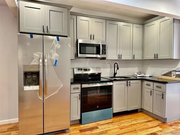 a kitchen with stainless steel appliances granite countertop a stove a sink and a refrigerator