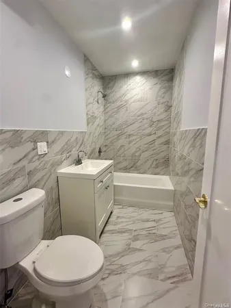 a white toilet sitting next to a bath tub
