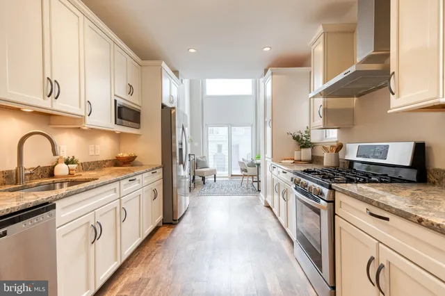 a large kitchen with stainless steel appliances granite countertop a stove and a sink