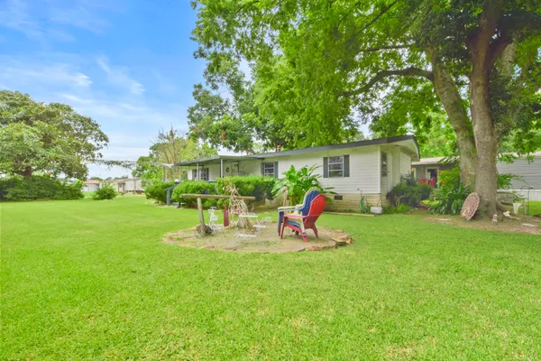 a view of a house with backyard sitting area and garden