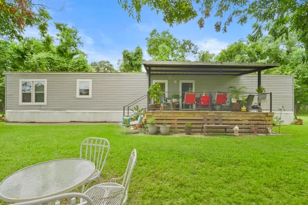 a view of a chair and table in the back yard of the house