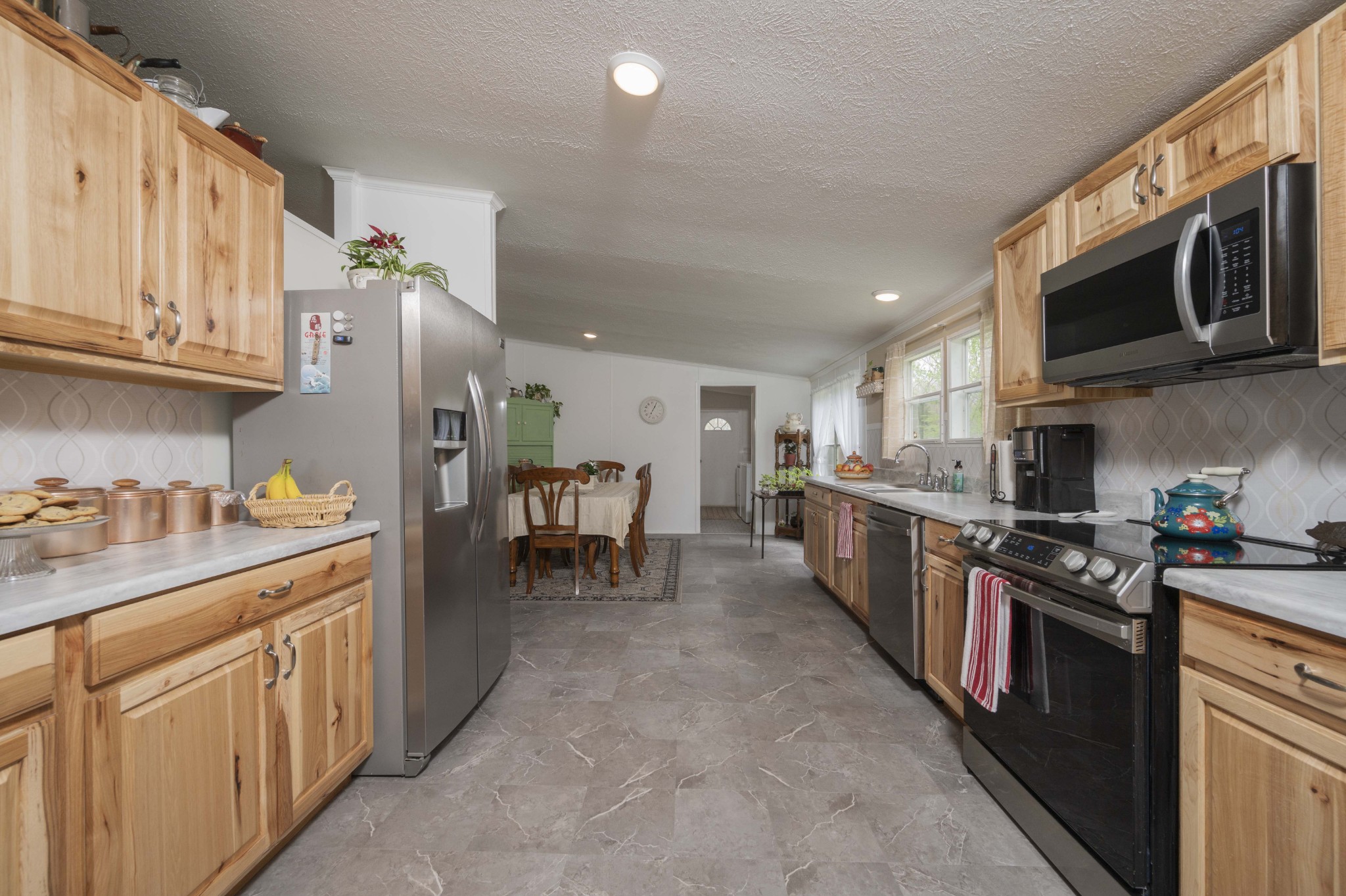 1822 Groveland Ridge Road Columbia, TN 38401 - Photo 17 of 48 a kitchen with stainless steel appliances granite countertop a stove top oven a sink dishwasher and a refrigerator with wooden cabinets