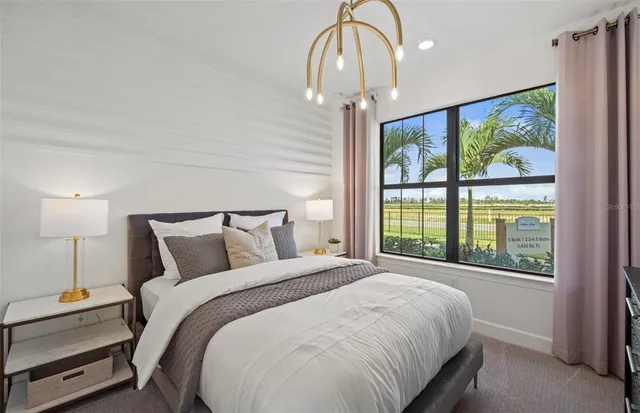 a bedroom with a large bed and a chandelier