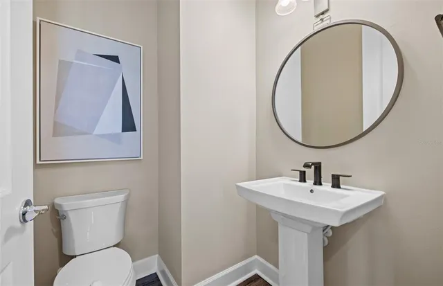 a bathroom with a toilet a sink and a mirror