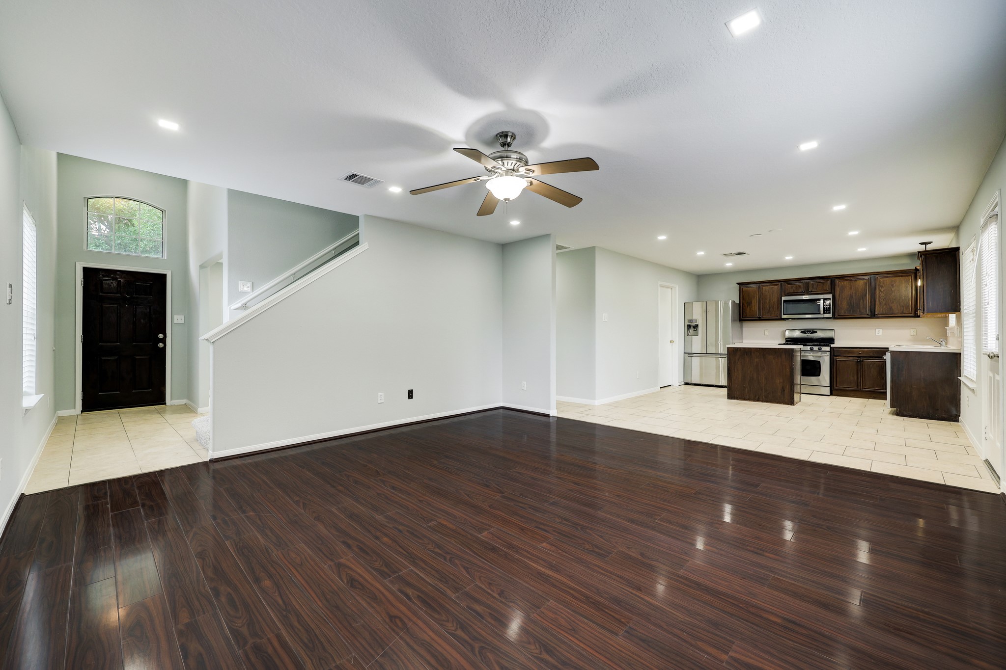 4906 Siros Isle Court Spring, TX 77389 - Photo 3 of 10 a view of an empty room with a kitchen and wooden floor