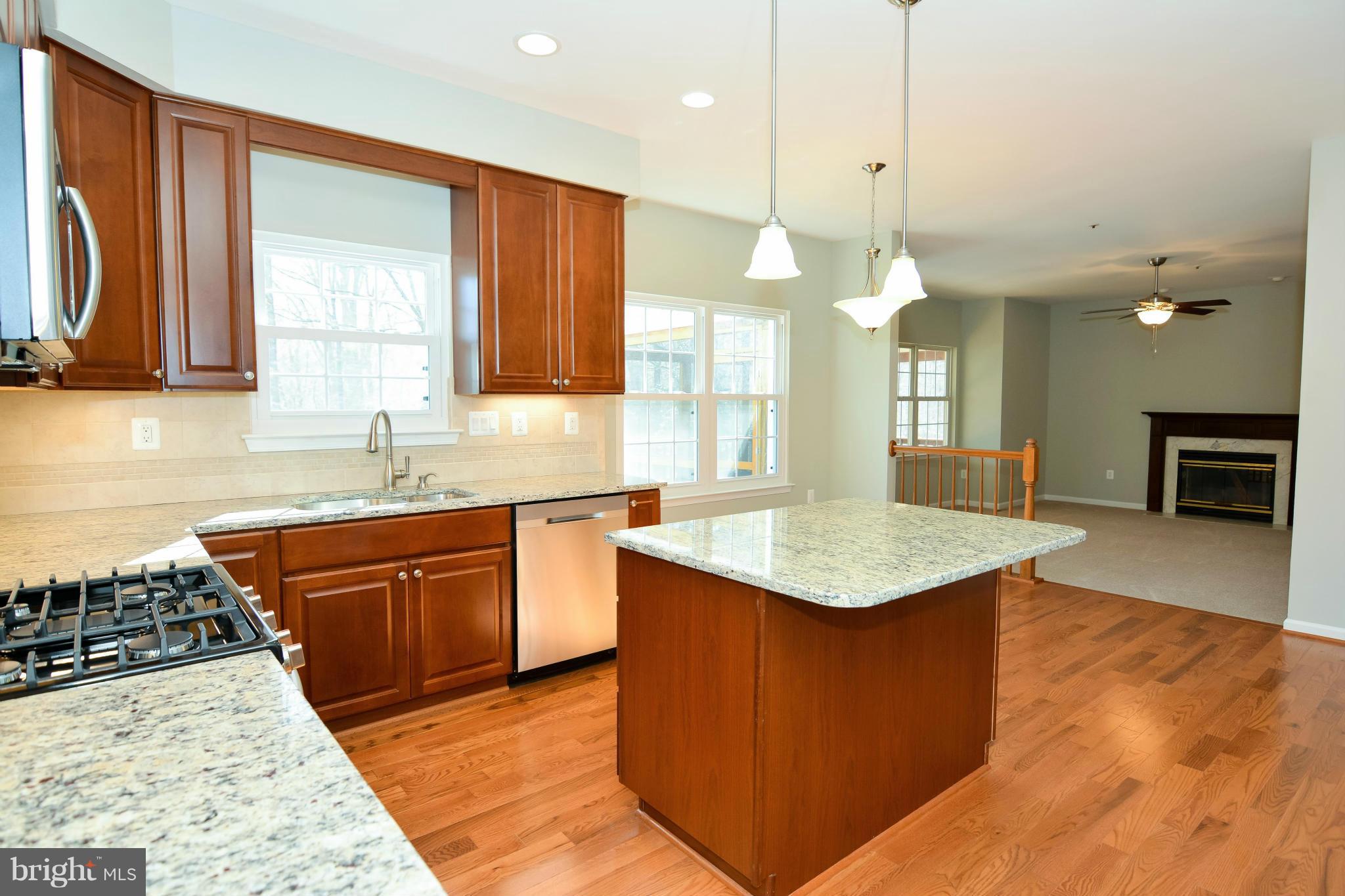 591 Small Reward Road Huntingtown, MD 20639 - Photo 12 of 30 a kitchen with kitchen island granite countertop a sink a counter top space appliances and a window