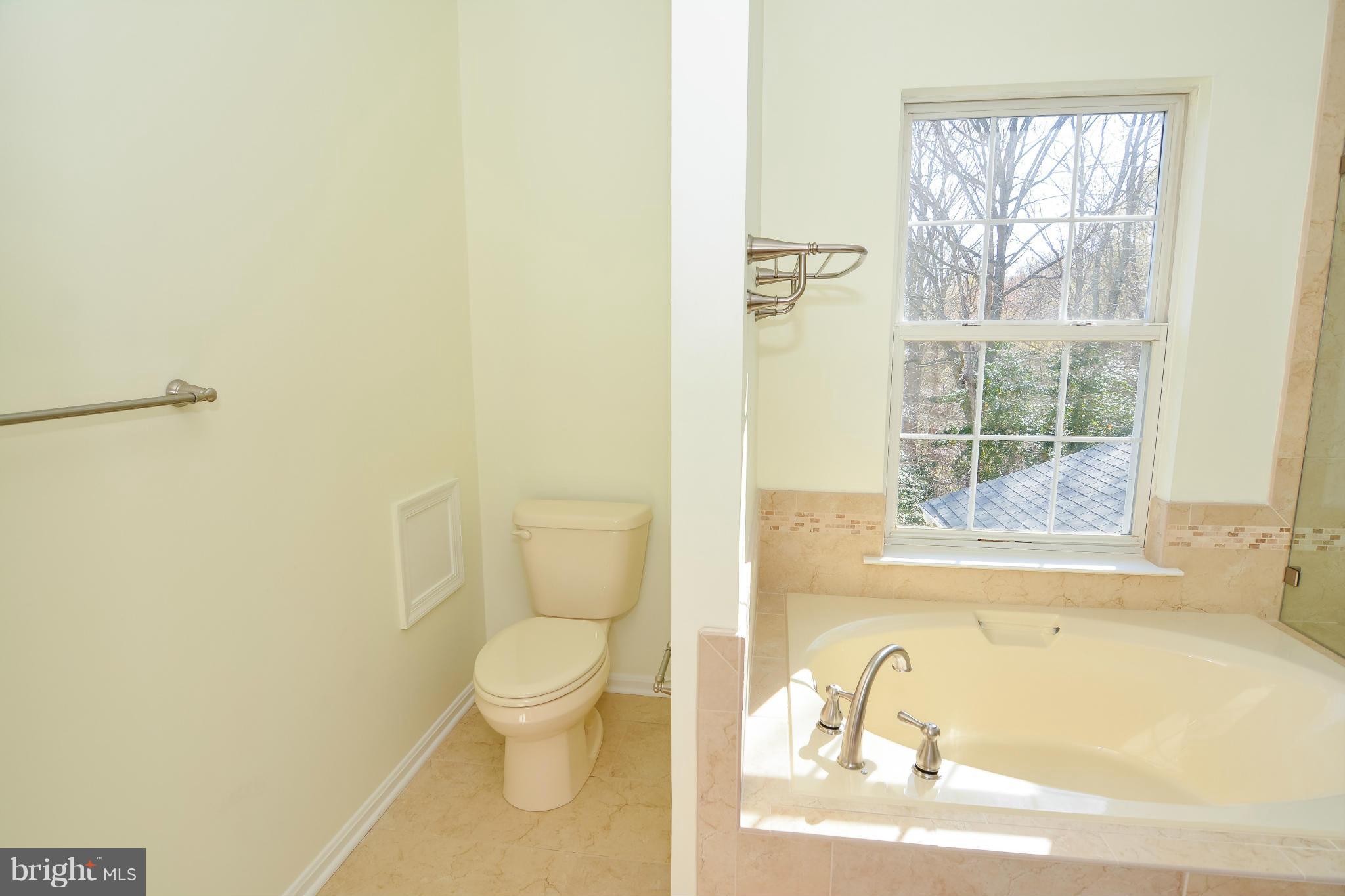 591 Small Reward Road Huntingtown, MD 20639 - Photo 22 of 30 a bathroom with a granite countertop toilet a sink and a bathtub