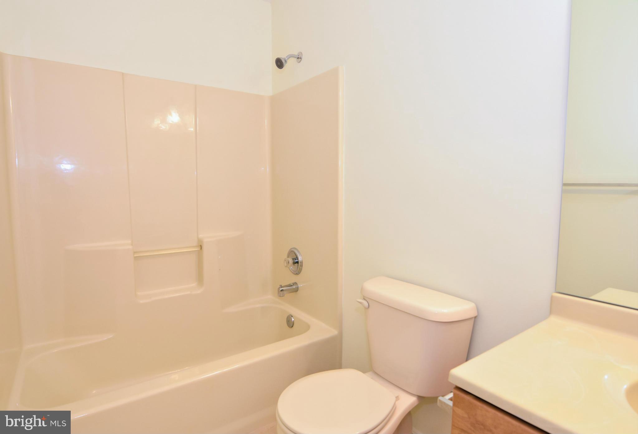 591 Small Reward Road Huntingtown, MD 20639 - Photo 25 of 30 a white toilet sitting next to a bathroom sink and tub