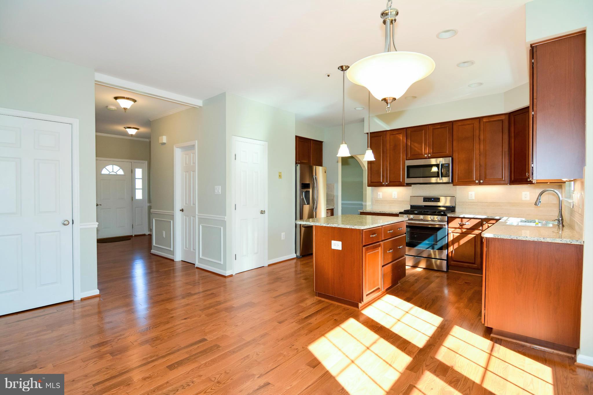 591 Small Reward Road Huntingtown, MD 20639 - Photo 9 of 30 a open kitchen with stainless steel appliances granite countertop a stove refrigerator and a sink