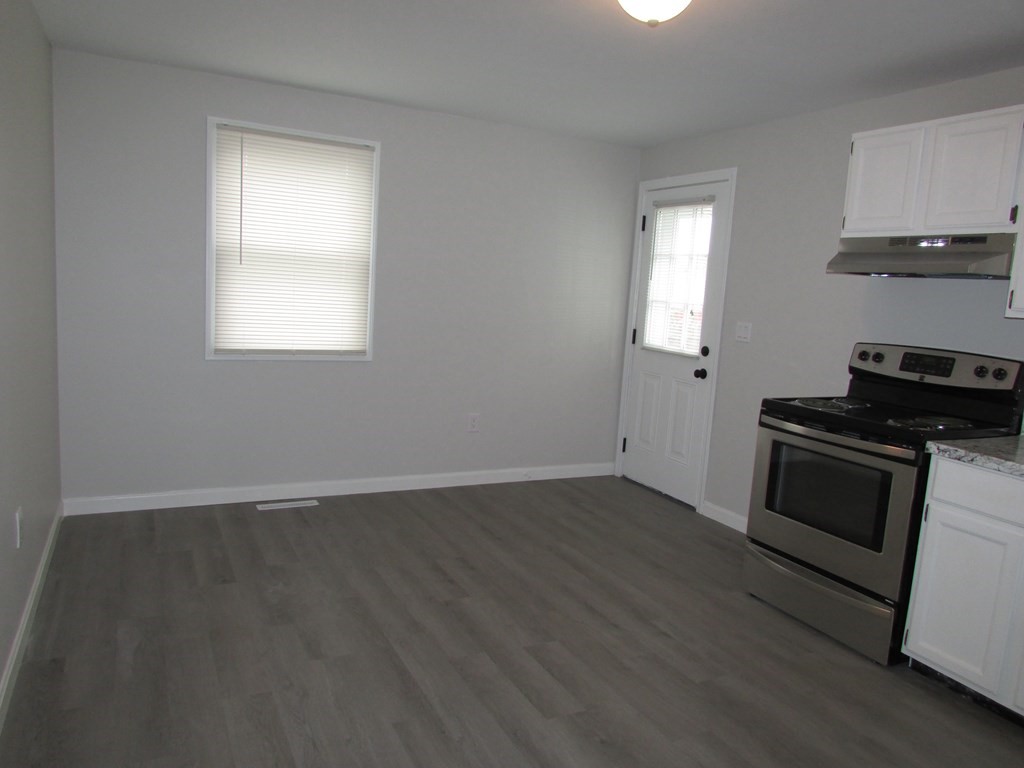 42-44 Wrentham Road Springfield, MA 01119 - Photo 12 of 31 an empty room with wooden floor cabinet and a window