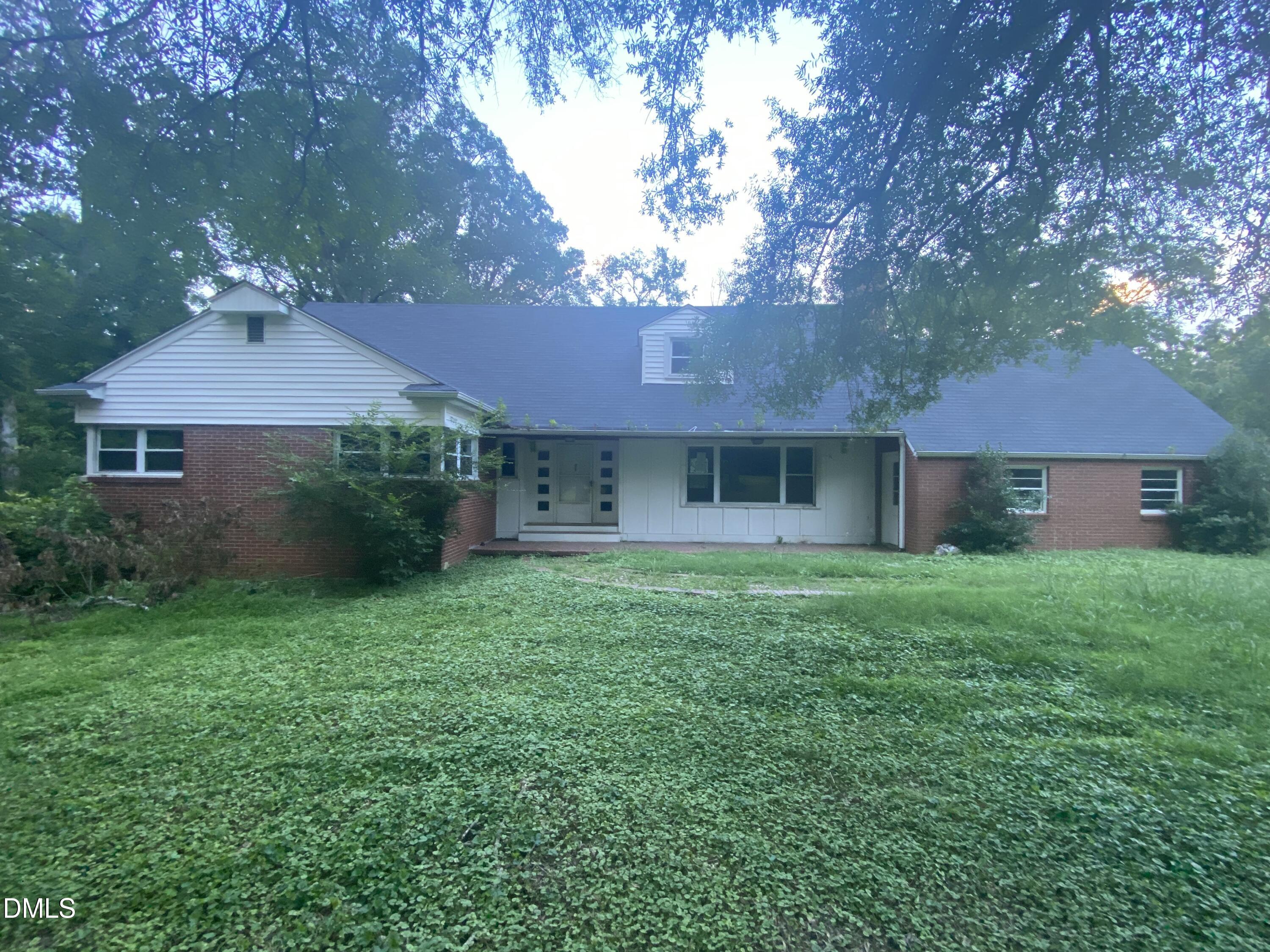 a view of a yard in front of a house with large tree