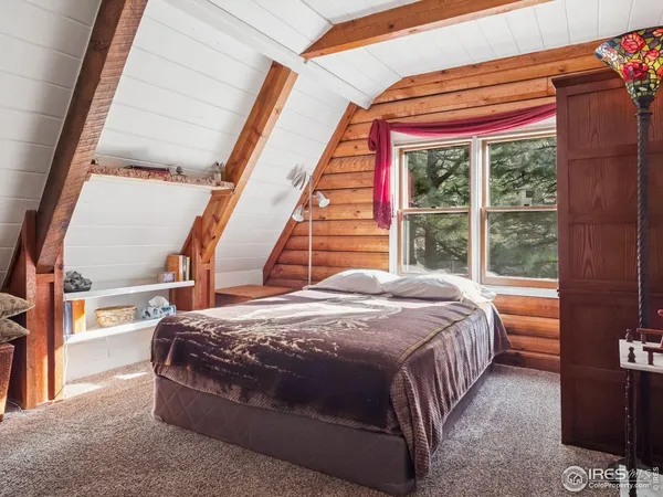 a bed sitting in a bedroom next to a window