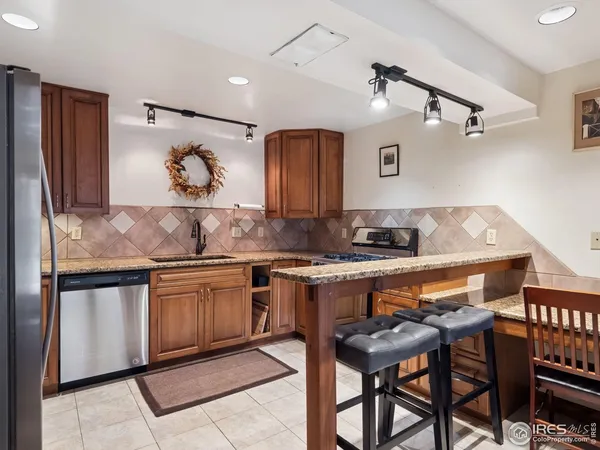 a kitchen with stainless steel appliances granite countertop a stove a refrigerator and a dining table