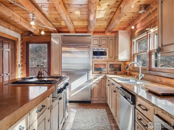 a kitchen with stainless steel appliances granite countertop a sink and a counter space