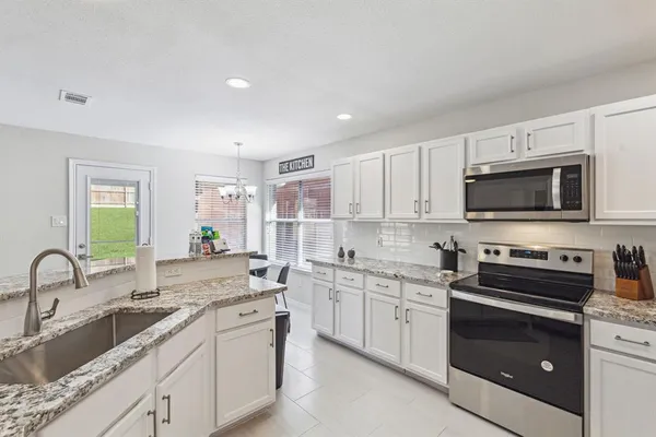 a kitchen with a sink stove and microwave