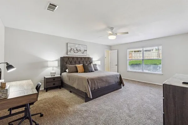 a bedroom with a large bed and a chandelier