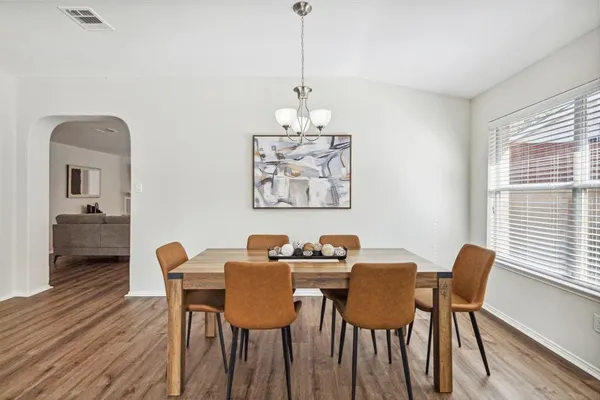 a dining room with furniture a window and wooden floor