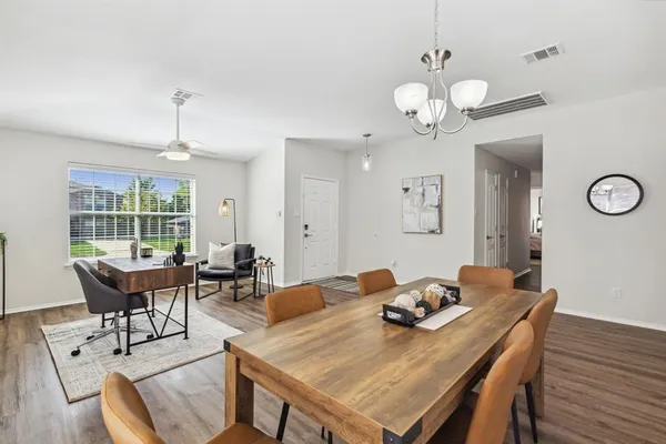 a view of a dining room with furniture a chandelier and wooden floor